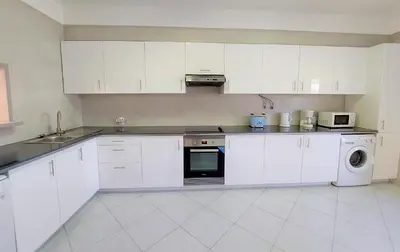 a white kitchen with white cabinets and a microwave at Vilamouratenis 'Blue' by SAPvillas in Vilamoura