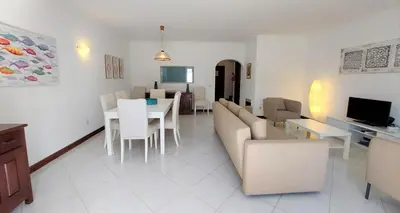 a living room with a couch and a table and chairs at Vilamouratenis 'Blue' by SAPvillas in Vilamoura
