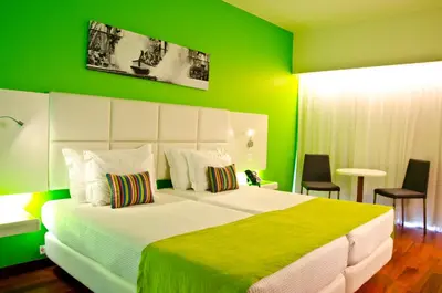 a bedroom with a large bed with green walls at Aquashow Park Hotel in Quarteira