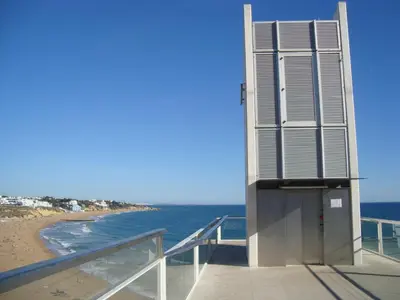 a building on the beach next to the ocean at Vila Algarvia Boutique & Suites in Albufeira