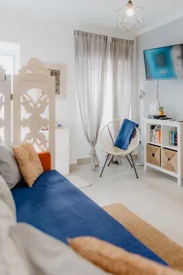 a bedroom with a blue bed and a chair at Home Santa Clara in Albufeira