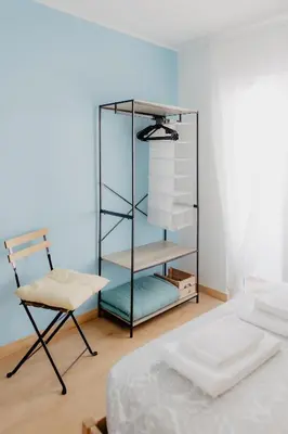 a bedroom with a glass book shelf and a chair at Home Santa Clara in Albufeira