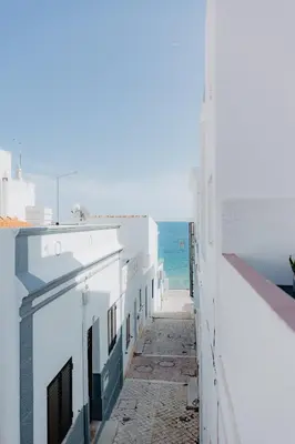 a view of the ocean from between buildings at Home Santa Clara in Albufeira