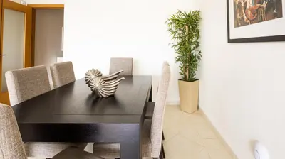 a dining room with a black table and chairs at House F São Rafael Beach - Free Wifi & Airco, NETFLIX ready - 300m from the beach in Albufeira