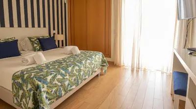 a bedroom with a bed and a wooden floor at House F São Rafael Beach - Free Wifi & Airco, NETFLIX ready - 300m from the beach in Albufeira