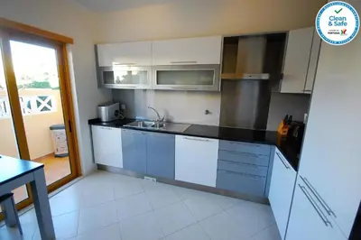 a kitchen with white cabinets and a sink at House F São Rafael Beach - Free Wifi & Airco, NETFLIX ready - 300m from the beach in Albufeira
