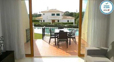 a balcony with a table and chairs in a house at House F São Rafael Beach - Free Wifi & Airco, NETFLIX ready - 300m from the beach in Albufeira
