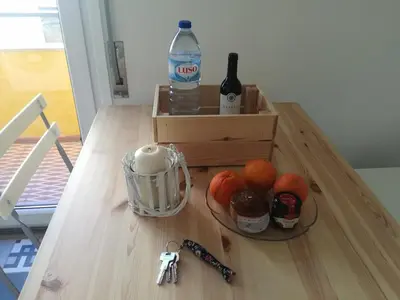 a table with a bottle of water and a bowl of fruit at Carmo Twenties Apartment in Faro