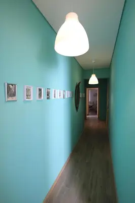 a hallway with blue walls and a light fixture at Carmo Twenties Apartment in Faro