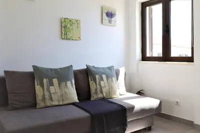 a couch in a living room with a window at Vila - Mar - Private outdoor Jacuzzi - wifi & airco - by bedzy in Albufeira