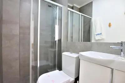 a bathroom with a shower and a toilet and a sink at Vila - Mar - Private outdoor Jacuzzi - wifi & airco - by bedzy in Albufeira