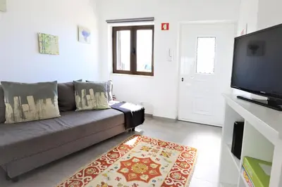a living room with a couch and a flat screen tv at Vila - Mar - Private outdoor Jacuzzi - wifi & airco - by bedzy in Albufeira