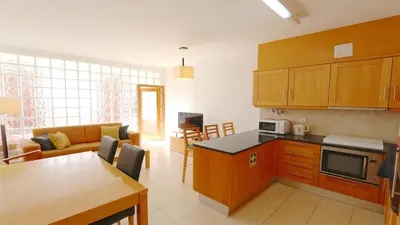 a kitchen and living room with a couch and a table at Terraços do Mar 46- Clever Details in Vilamoura