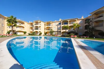 a swimming pool in front of a large apartment building at Praia Village 104 - Clever Details in Vilamoura