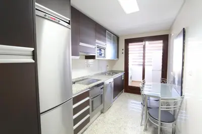 a kitchen with stainless steel appliances and a glass table at Monte Laguna - Clever Details in Vilamoura