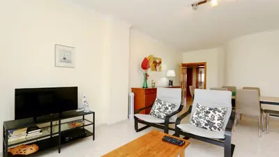 a living room with a television and a table and chairs at Falésia Marina - Clever Details in Vilamoura