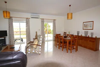 a living room with a table and a dining room at Falésia Marina - Clever Details in Vilamoura