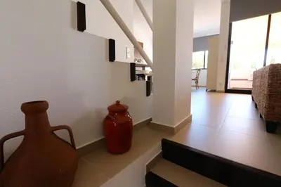 a living room with a vase sitting on the floor at Marina Parque - Clever Details in Vilamoura