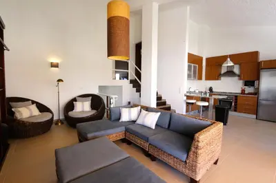 a living room with a couch and chairs and a kitchen at Marina Parque - Clever Details in Vilamoura