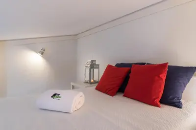 a bedroom with red and blue pillows on a bed at BmyGuest - Quinta do Lago Mezzanine Apartment in Almancil