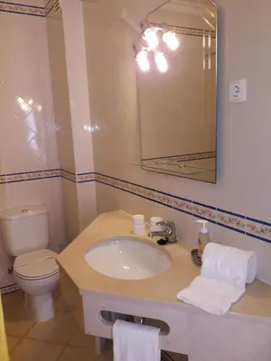 a bathroom with a sink and a toilet and a mirror at Apartamentos Colina do Mar Downtown Albufeira in Albufeira