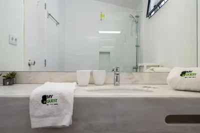 a bathroom with a sink and a mirror and towels at BmyGuest - Quinta do Lago Terrace Apartment I in Quinta do Lago