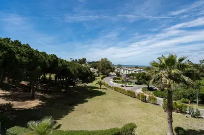 a park with palm trees and a road at BmyGuest - Quinta do Lago Terrace Apartment I in Quinta do Lago
