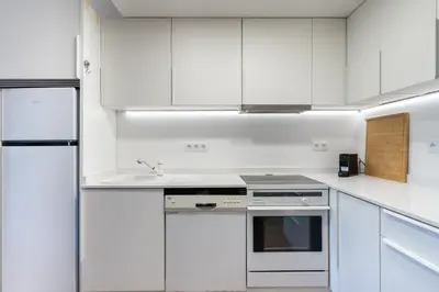 a kitchen with white cabinets and a sink at BmyGuest - Quinta do Lago Terrace Apartment II in Quinta do Lago
