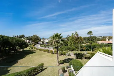 a view of a park with palm trees and a road at BmyGuest - Quinta do Lago Terrace Apartment II in Quinta do Lago