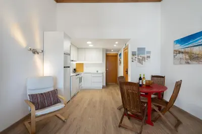 a kitchen and dining room with a red table and chairs at BmyGuest - Quinta do Lago Terrace Apartment II in Quinta do Lago