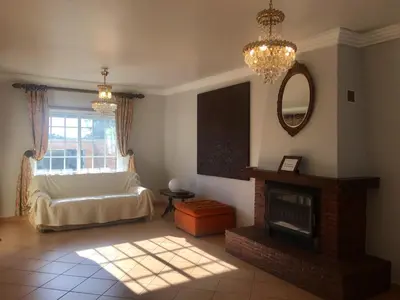 a living room with a fireplace and a white couch at Casa das Figuras in Faro