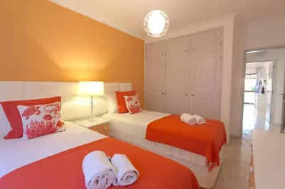 two beds in a room with orange and white at Pinhal do Golf - Clever Details in Vilamoura