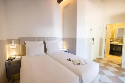 a bedroom with a large white bed with a book on it at Pestana Vila Sol - Vilamoura Premium Golf Resort in Vilamoura