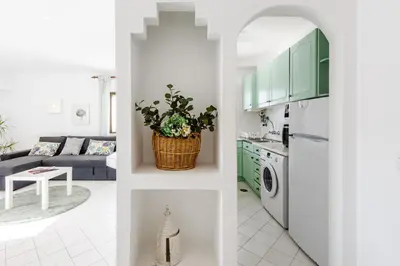 a kitchen and a living room with green cabinets at Casas Barulho Apartments Old Town in Albufeira