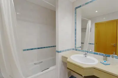 a bathroom with a sink and a tub and a mirror at Terraços de Vilamoura 55- Clever Details in Vilamoura