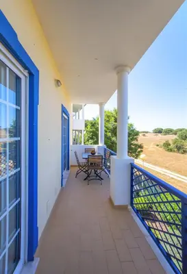 a balcony with a table and chairs on a house at Olhos de Água Apartment Albufeira II in Albufeira