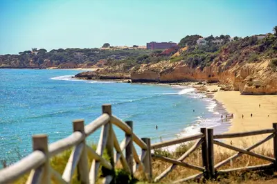 a view of a beach with a wooden fence at Olhos de Água Apartment Albufeira II in Albufeira