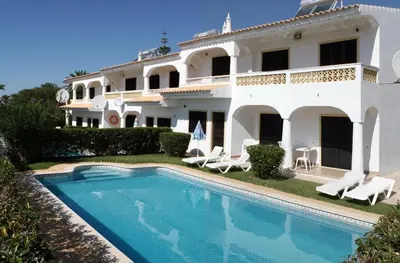 a large white house with a swimming pool in front of it at Villa Estela in Albufeira