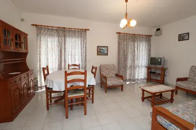 a dining room with a table and chairs and a tv at Villa Estela in Albufeira