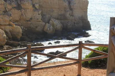 a wooden fence in front of the ocean at Villa Lena in Albufeira