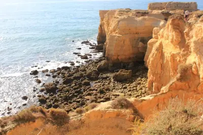 a rocky beach with the ocean in the background at Villa Lena in Albufeira