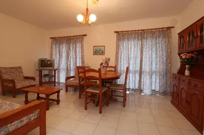 a living room with a table and chairs and a television at Villa Lena in Albufeira