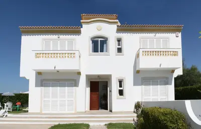 a white house with a red door at Villa Gonçalves in Albufeira