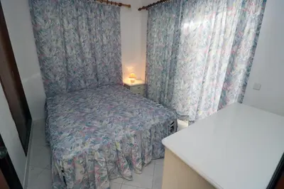 a small bedroom with a bed and a window at Villa Gonçalves in Albufeira