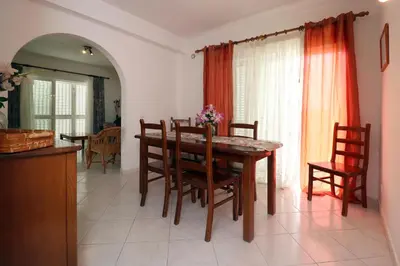 a dining room with a wooden table and chairs at Villa Gonçalves in Albufeira