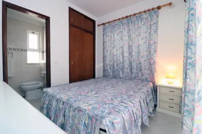 a bedroom with a bed and a toilet and a window at Villa Gonçalves in Albufeira
