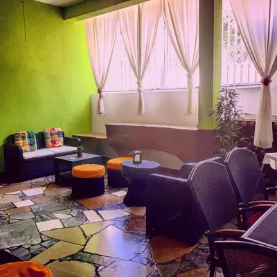 a room with chairs and tables and a window at Guest House Oliveira in Boliqueime