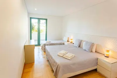two beds in a white room with two lamps at Marina Vilamoura - Aquamar 013 - By VilamouraSun in Vilamoura