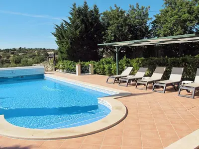 a swimming pool with lounge chairs and a pavilion at Holiday Home Montinho by Interhome in Loulé