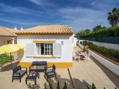 a patio with chairs and an umbrella and a house at Holiday Home Monte Novo by Interhome in Paderne
